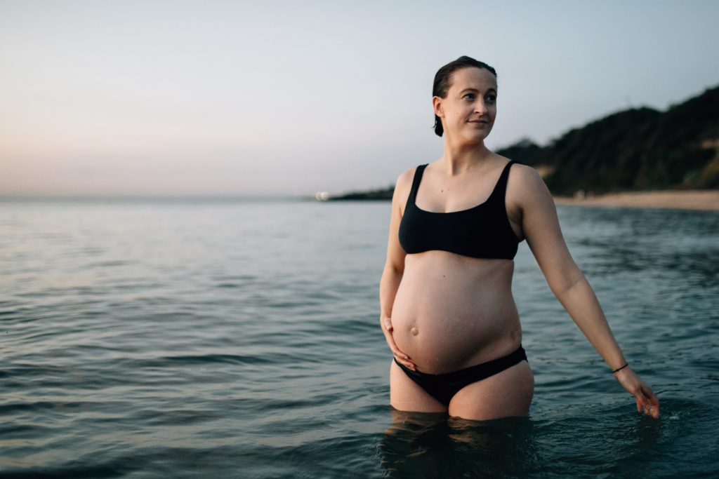 pregnant woman trailing hand in water during beach maternity photos, And So I Don't Forget Photography