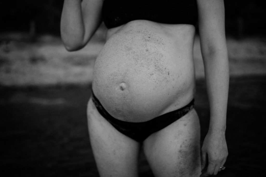 bare pregnant belly looking misshapen during beach maternity photos, And So I Don't Forget Photography