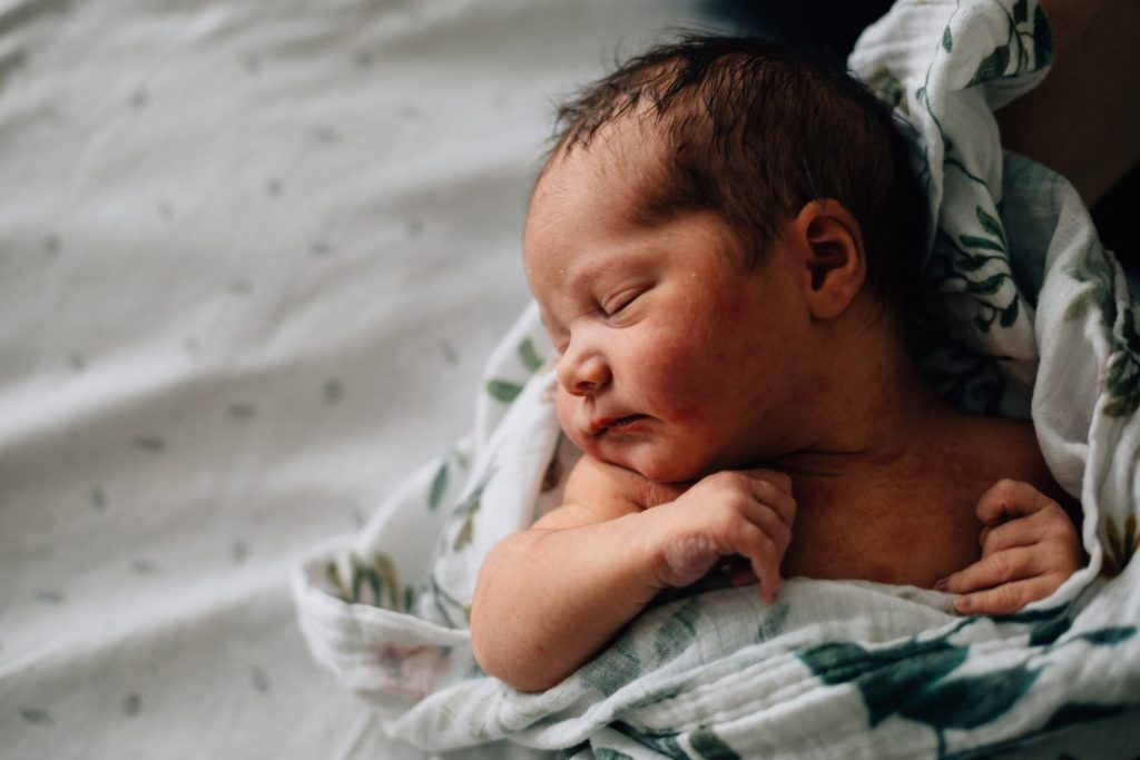 baby asleep in hospital bassinette in wrap natural newborn photography melbourne