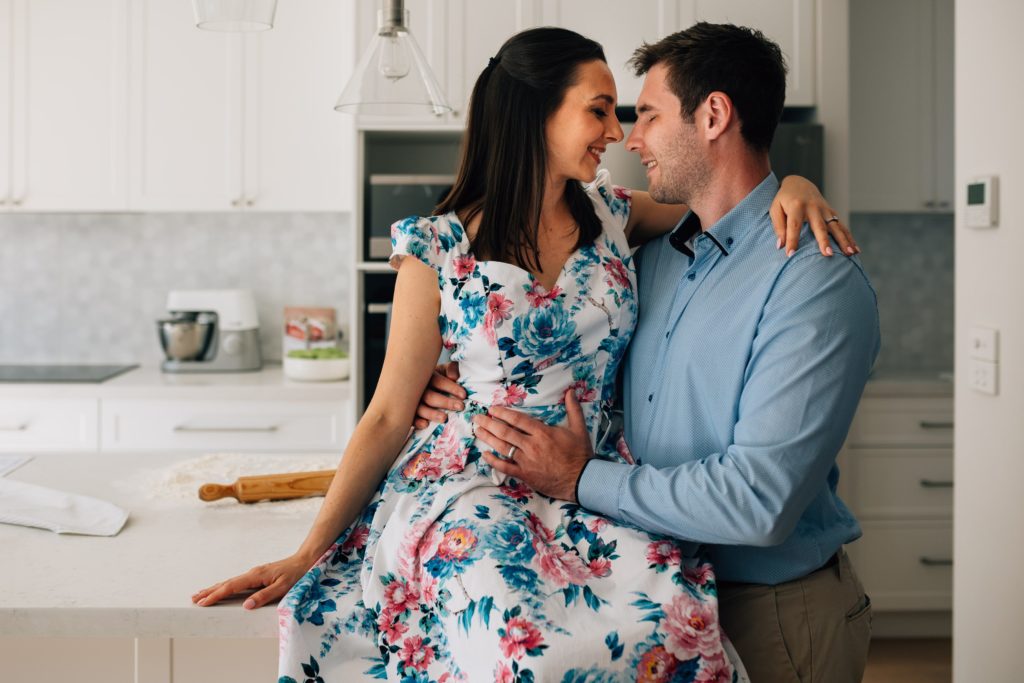 man and woman in kitchen, bun in the oven pregnancy announcement photo session