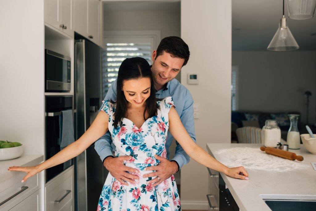 bun in the oven pregnancy announcement, couple in kitchen together for photography session