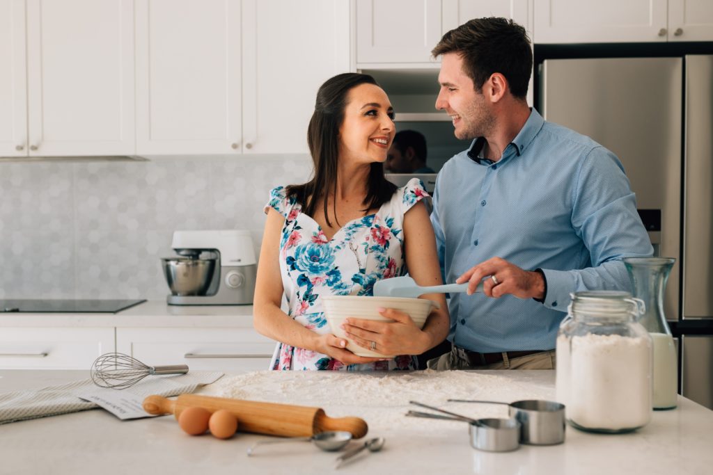 man and woman in kitchen holding mixing bowl 