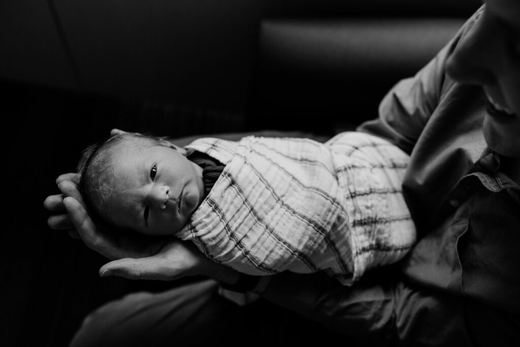 Black and white image, newborn baby lying on Dad's outstretched arms.  Fresh 48 at St Vincent's Private