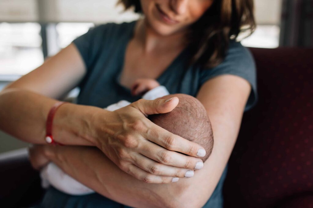 Mum stroking newborn baby's head